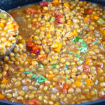 A ladle with smoky vegetarian lentil soup being lifted from the slow cooker