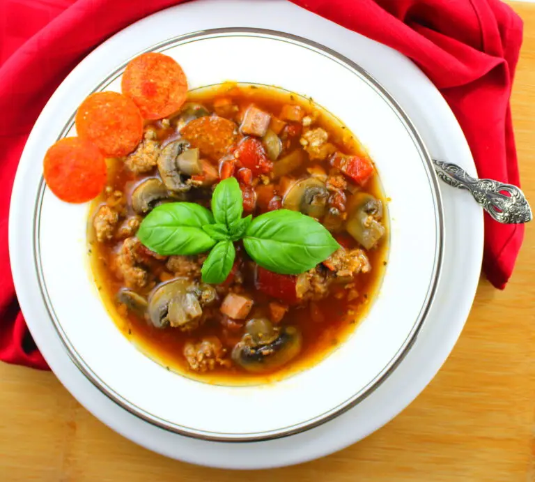 Bowl of Paleo Pizza Soup garnished with pepperoni slices and fresh basil
