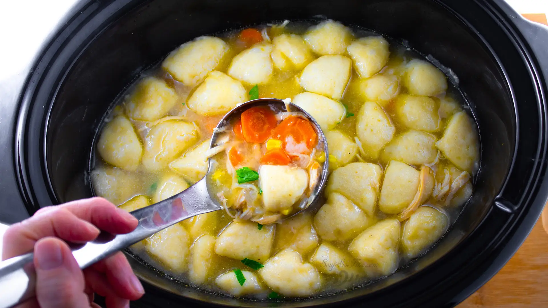 Chicken Dumpling Soup Crockpot showing ladle of soup in crockpot